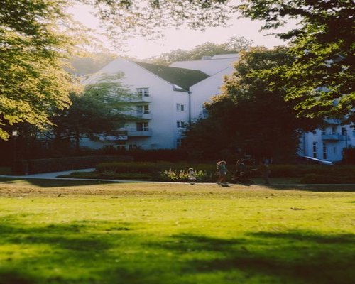A family taking a relaxed walk in a sunny urban park during the weekend
